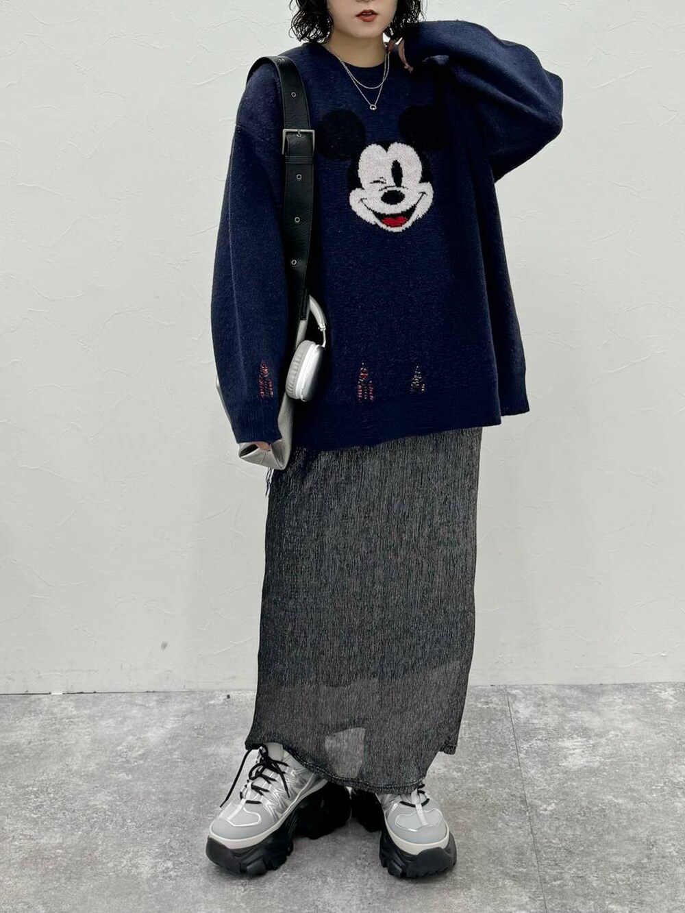 グレー系のスニーカー、シルバー系のトートバッグ、ブラック系のスカートを着用したレディースの秋コーディネートの2枚目の写真