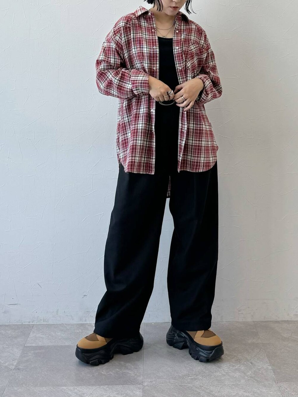 レッド系のシャツ/ブラウス、ブラック系のスラックスを着用したレディースの夏コーディネートの7枚目の写真