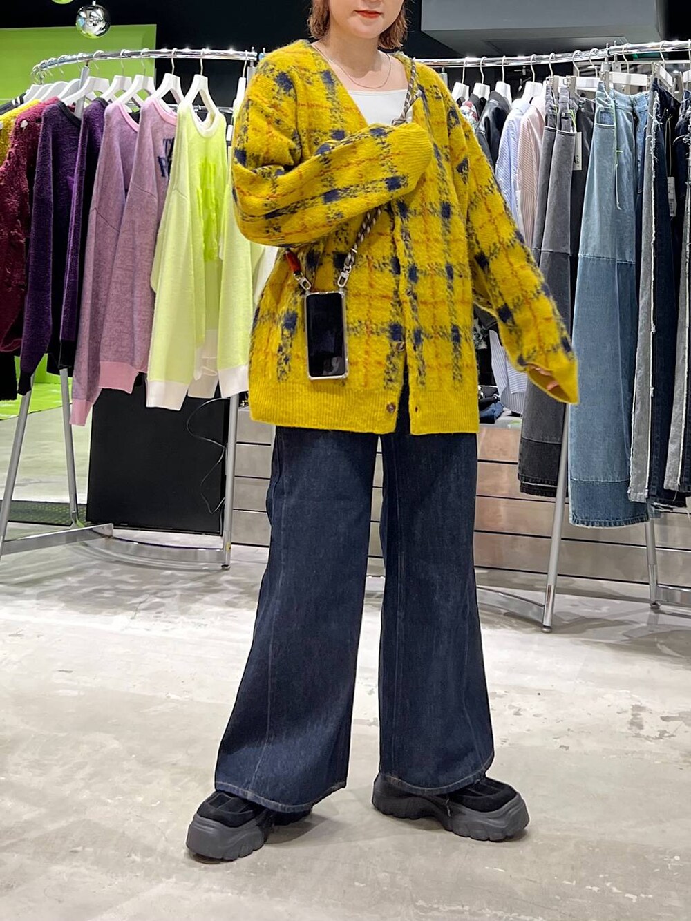 ブルー系のデニムパンツ、イエロー系のカーディガン/ボレロ、ブラック系のニットキャップ/ビーニーを着用したレディースの夏コーディネートの4枚目の写真