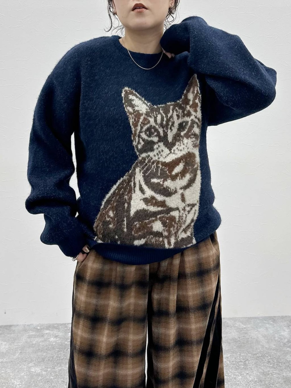 ブラウン系のローファー、ブラウン系のスラックス、ブルー系のニット/セーターを着用したレディースの秋コーディネートの3枚目の写真