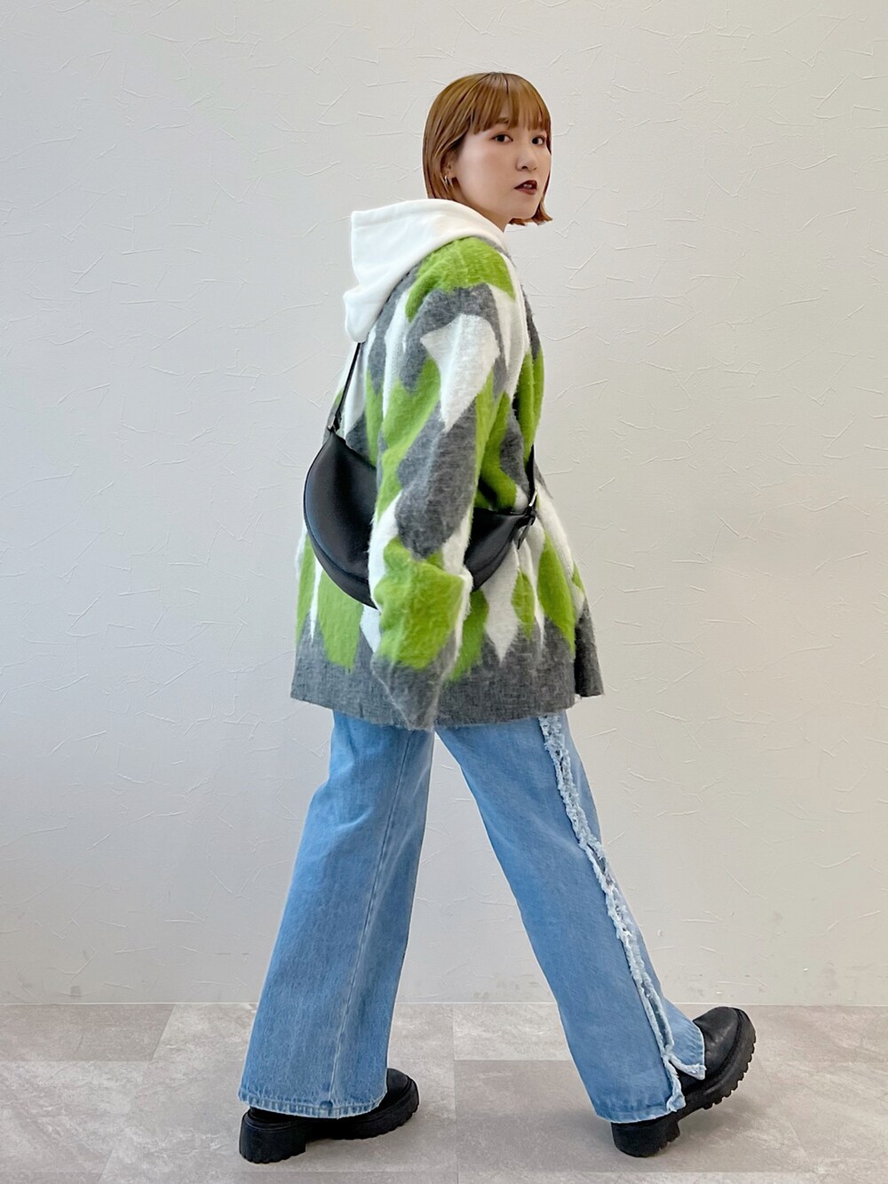 ブルー系のデニムパンツ、ブラック系のブーツ、グリーン系のカーディガン/ボレロを着用したレディースの冬コーディネートの2枚目の写真