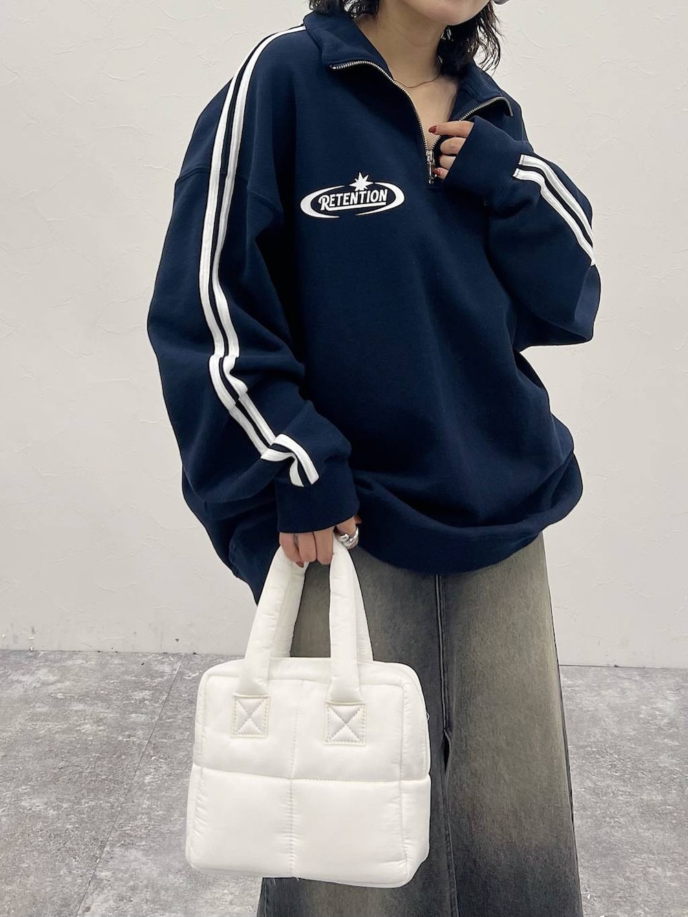 ホワイト系のハンドバッグ、ブラック系のスカート、ブルー系のスウェットを着用したレディースの秋コーディネートの5枚目の写真