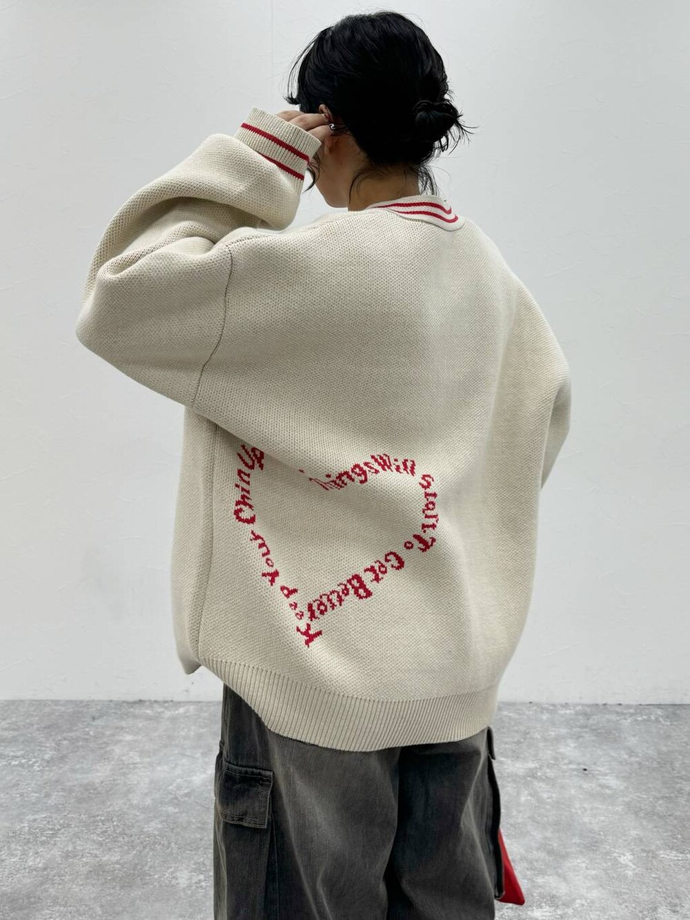 ブラック系のデニムパンツ、ベージュ系のカーディガン/ボレロを着用したレディースの秋コーディネートの3枚目の写真