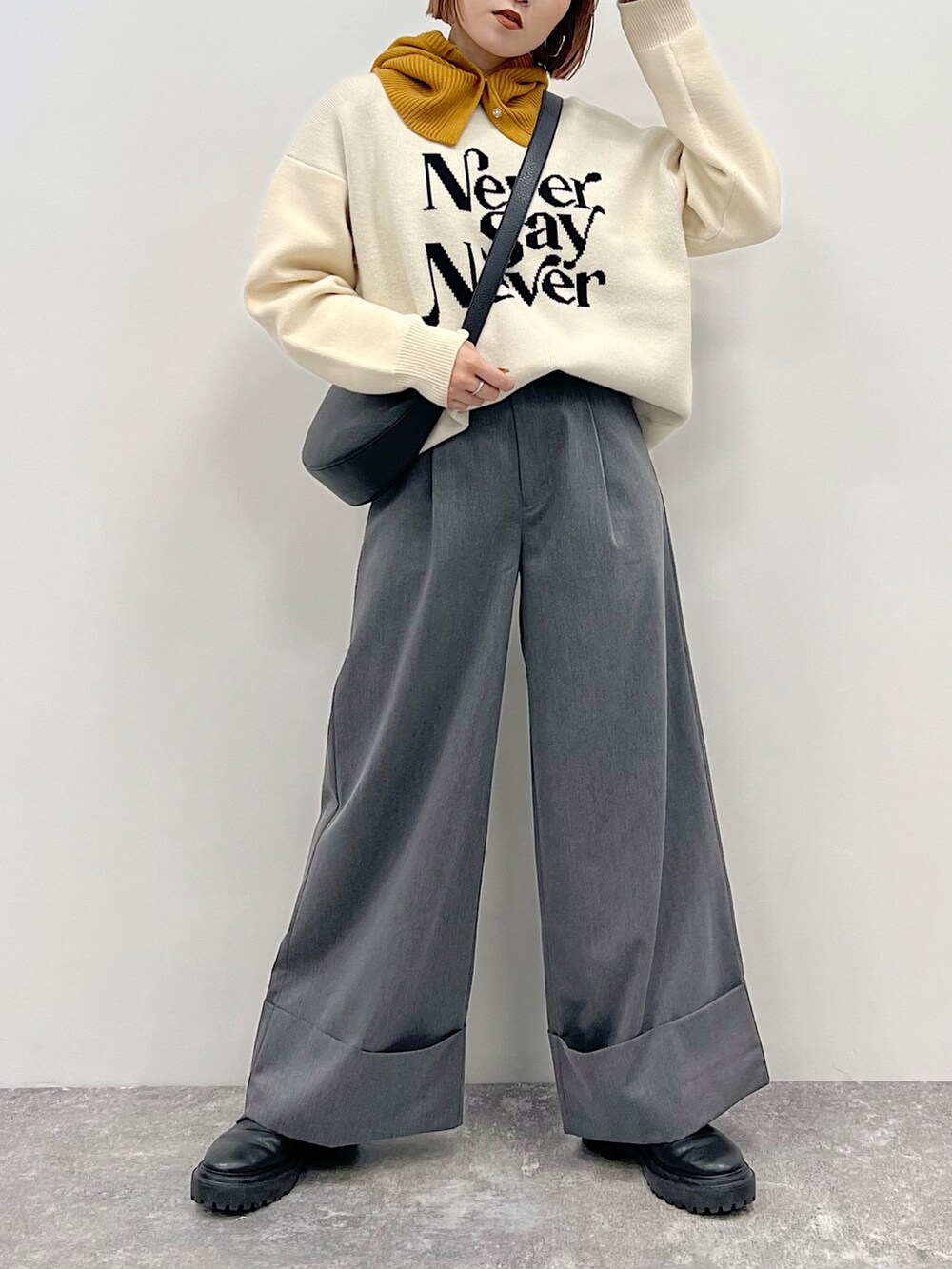 ベージュ系のニット/セーター、グレー系のスラックス、ブラック系のブーツを着用したレディースの秋コーディネートの2枚目の写真