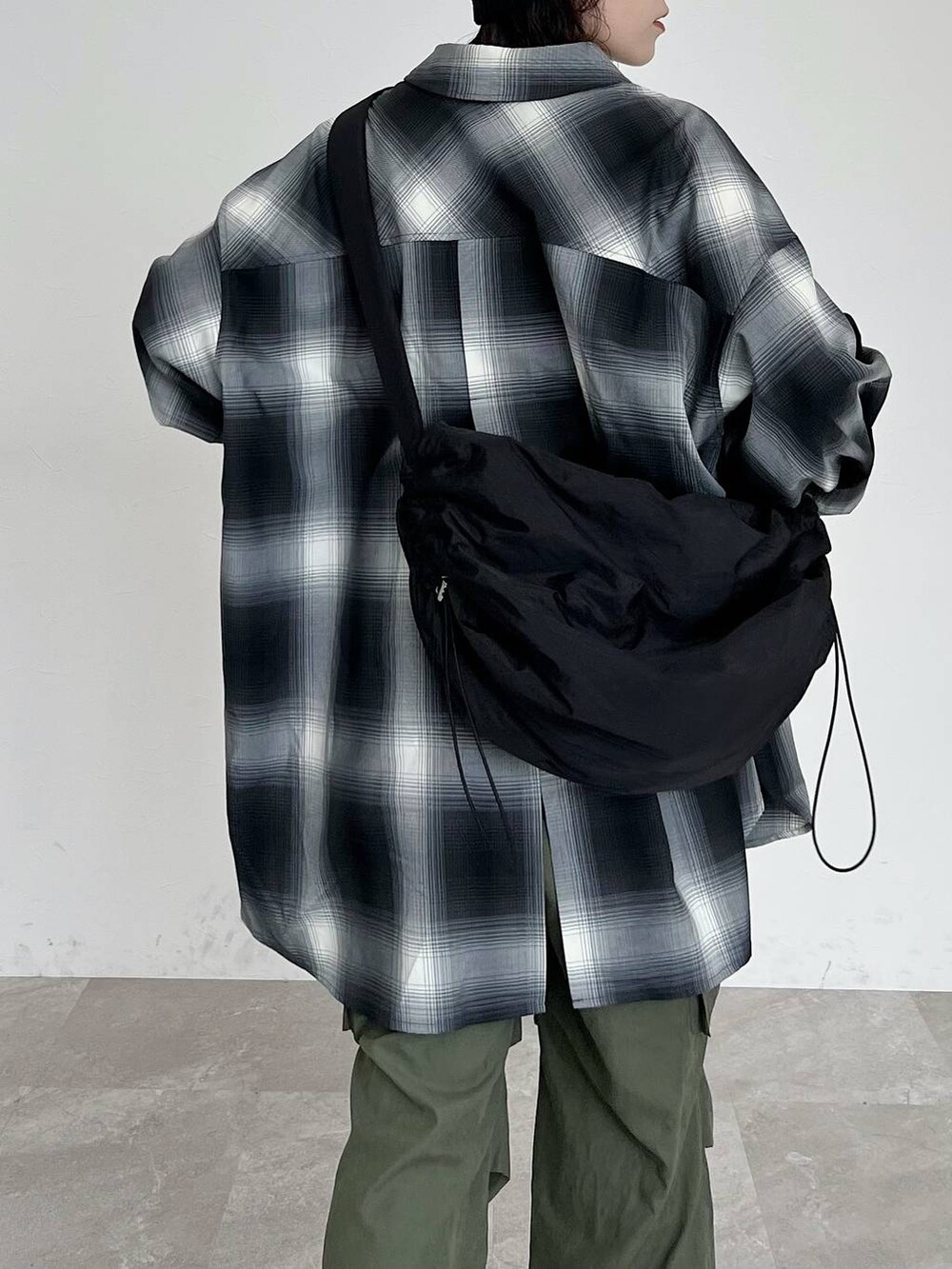 ブラック系のシャツ/ブラウス、ブラック系のショルダーバッグ、グリーン系のカーゴパンツを着用したレディースの秋コーディネートの5枚目の写真