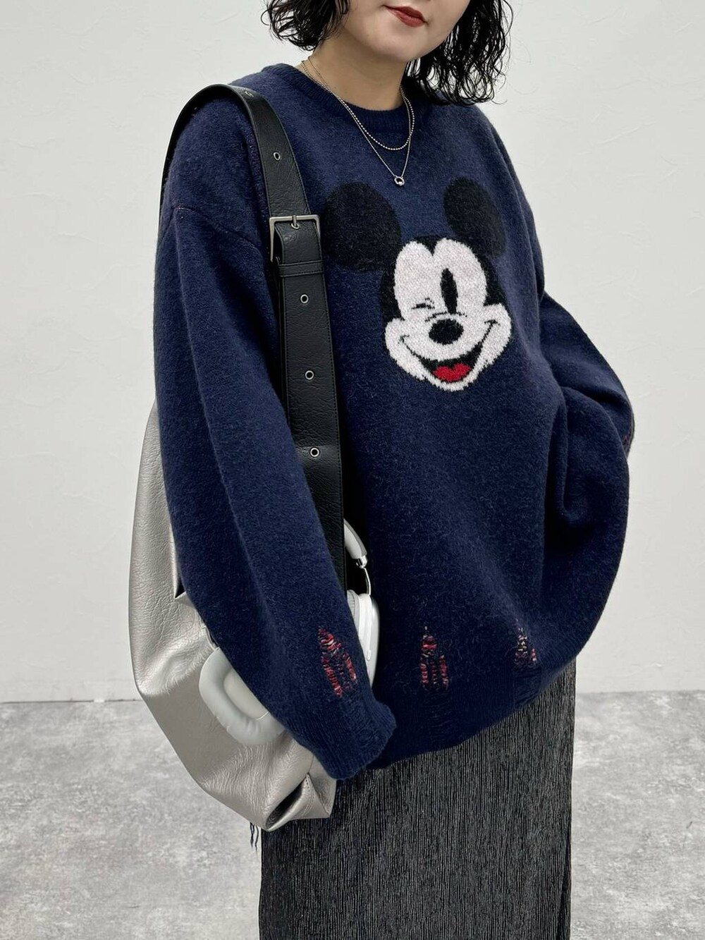 グレー系のスニーカー、シルバー系のトートバッグ、ブラック系のスカートを着用したレディースの秋コーディネートの4枚目の写真