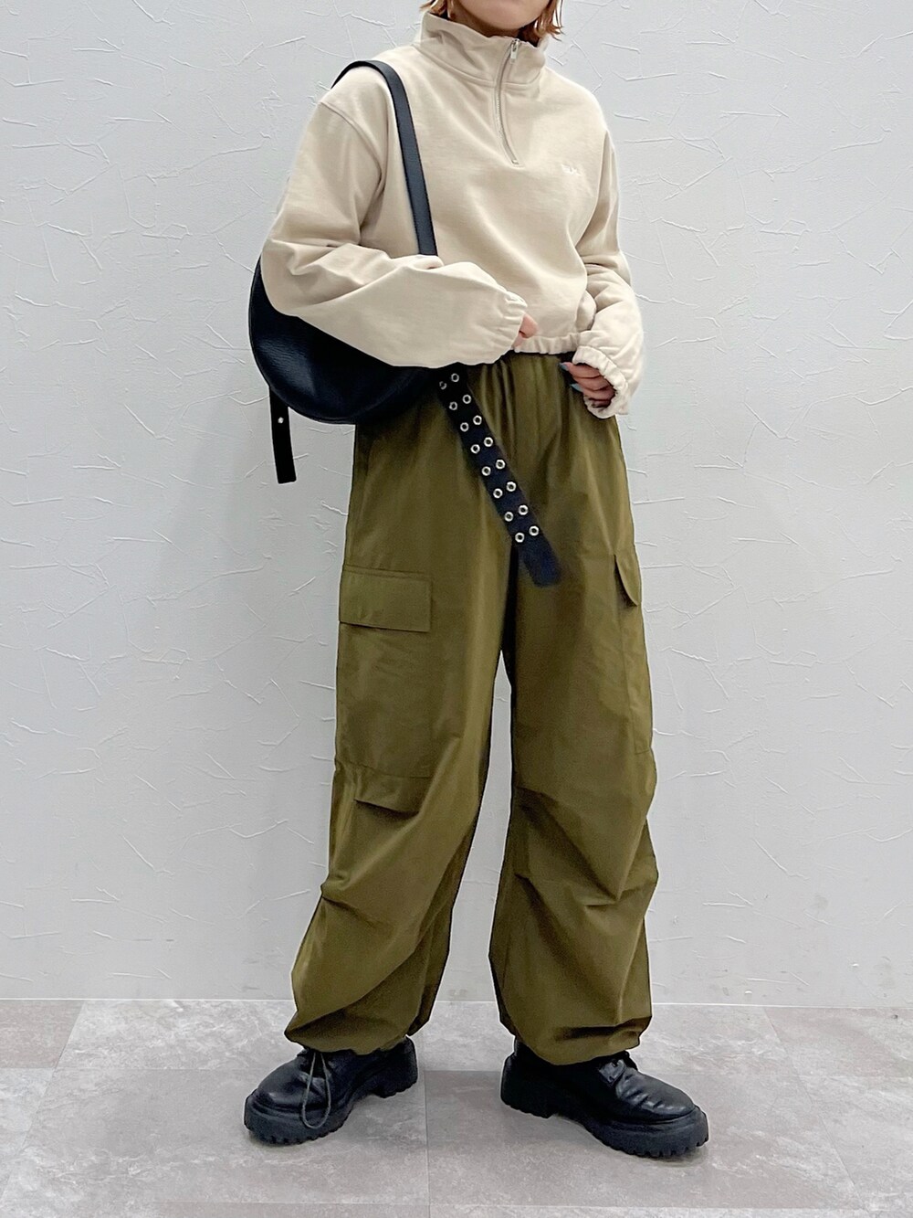 ブラック系のショルダーバッグ、グリーン系のその他パンツ、ブラック系のブーツを着用したレディースの冬コーディネートの3枚目の写真