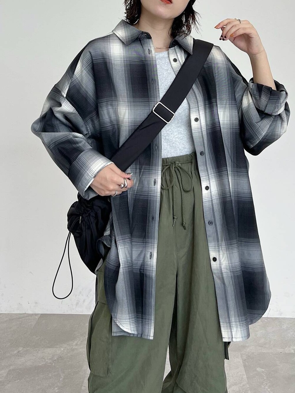 ブラック系のシャツ/ブラウス、ブラック系のショルダーバッグ、グリーン系のカーゴパンツを着用したレディースの秋コーディネートの4枚目の写真