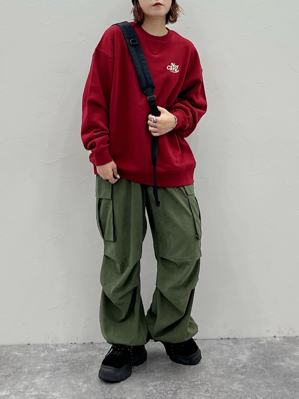 グリーン系のカーゴパンツ、レッド系のスウェット、ブラック系のニットキャップ/ビーニーを着用したレディースの秋コーディネートの3枚目の写真
