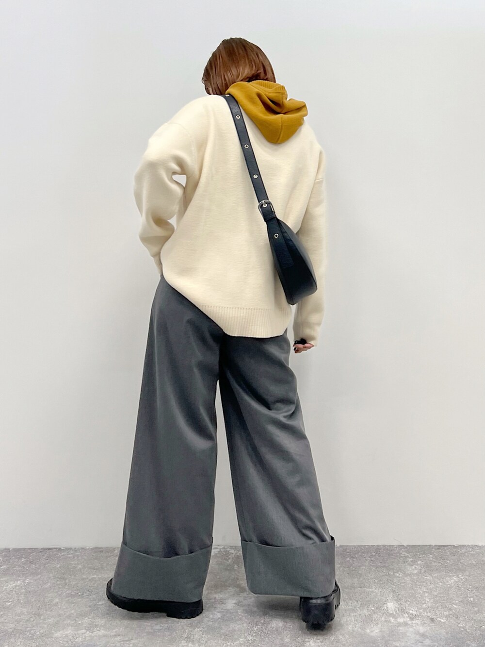 ベージュ系のニット/セーター、グレー系のスラックス、ブラック系のブーツを着用したレディースの秋コーディネートの4枚目の写真