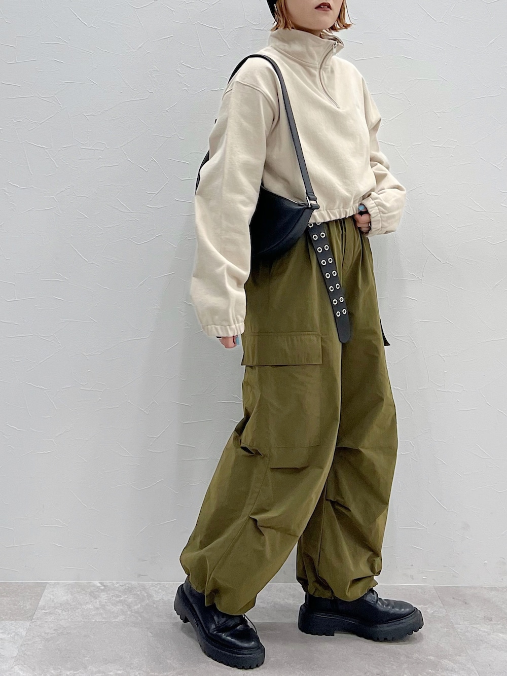 ブラック系のショルダーバッグ、グリーン系のその他パンツ、ブラック系のブーツを着用したレディースの冬コーディネートの4枚目の写真