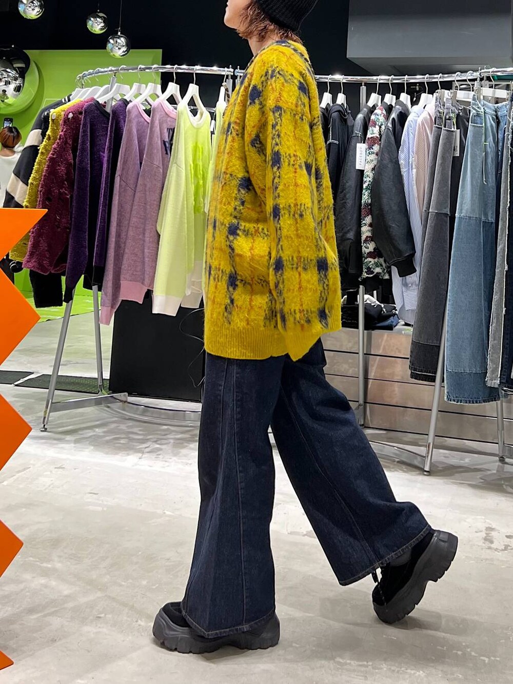 ブルー系のデニムパンツ、イエロー系のカーディガン/ボレロ、ブラック系のニットキャップ/ビーニーを着用したレディースの夏コーディネートの3枚目の写真