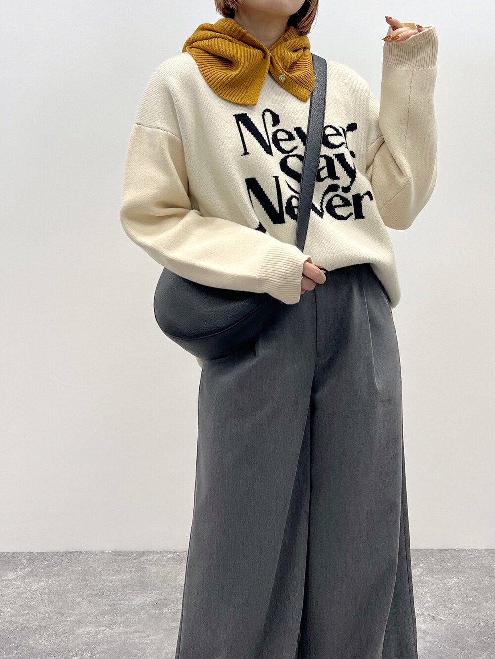 ベージュ系のニット/セーター、グレー系のスラックス、ブラック系のブーツを着用したレディースの秋コーディネートの5枚目の写真