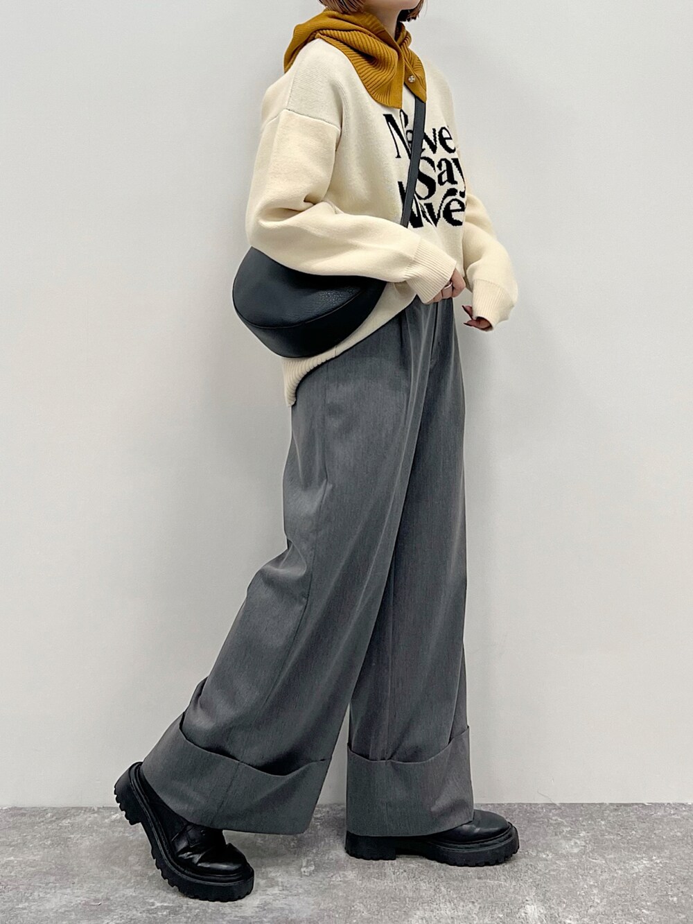 ベージュ系のニット/セーター、グレー系のスラックス、ブラック系のブーツを着用したレディースの秋コーディネートの3枚目の写真