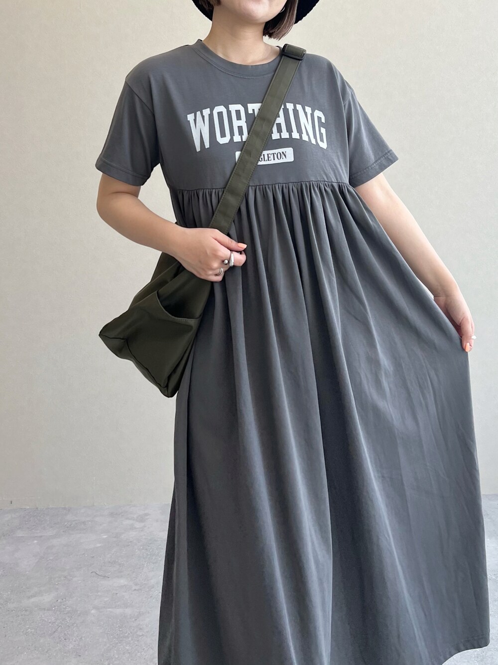 グリーン系のショルダーバッグ、ブラック系のサンダル、グレー系のワンピースを着用したレディースの春コーディネートの4枚目の写真