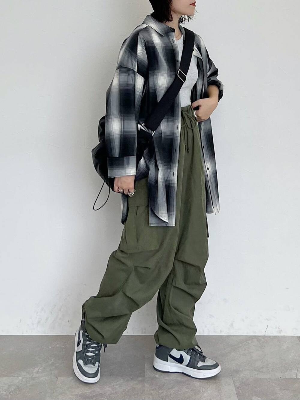 ブラック系のシャツ/ブラウス、ブラック系のショルダーバッグ、グリーン系のカーゴパンツを着用したレディースの秋コーディネートの2枚目の写真