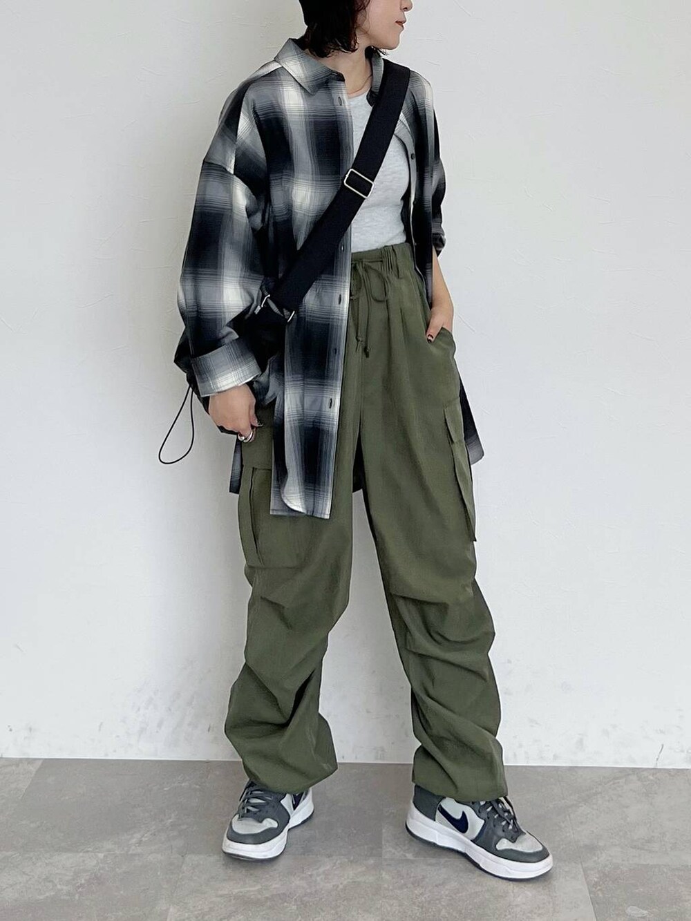 ブラック系のシャツ/ブラウス、ブラック系のショルダーバッグ、グリーン系のカーゴパンツを着用したレディースの秋コーディネートの3枚目の写真