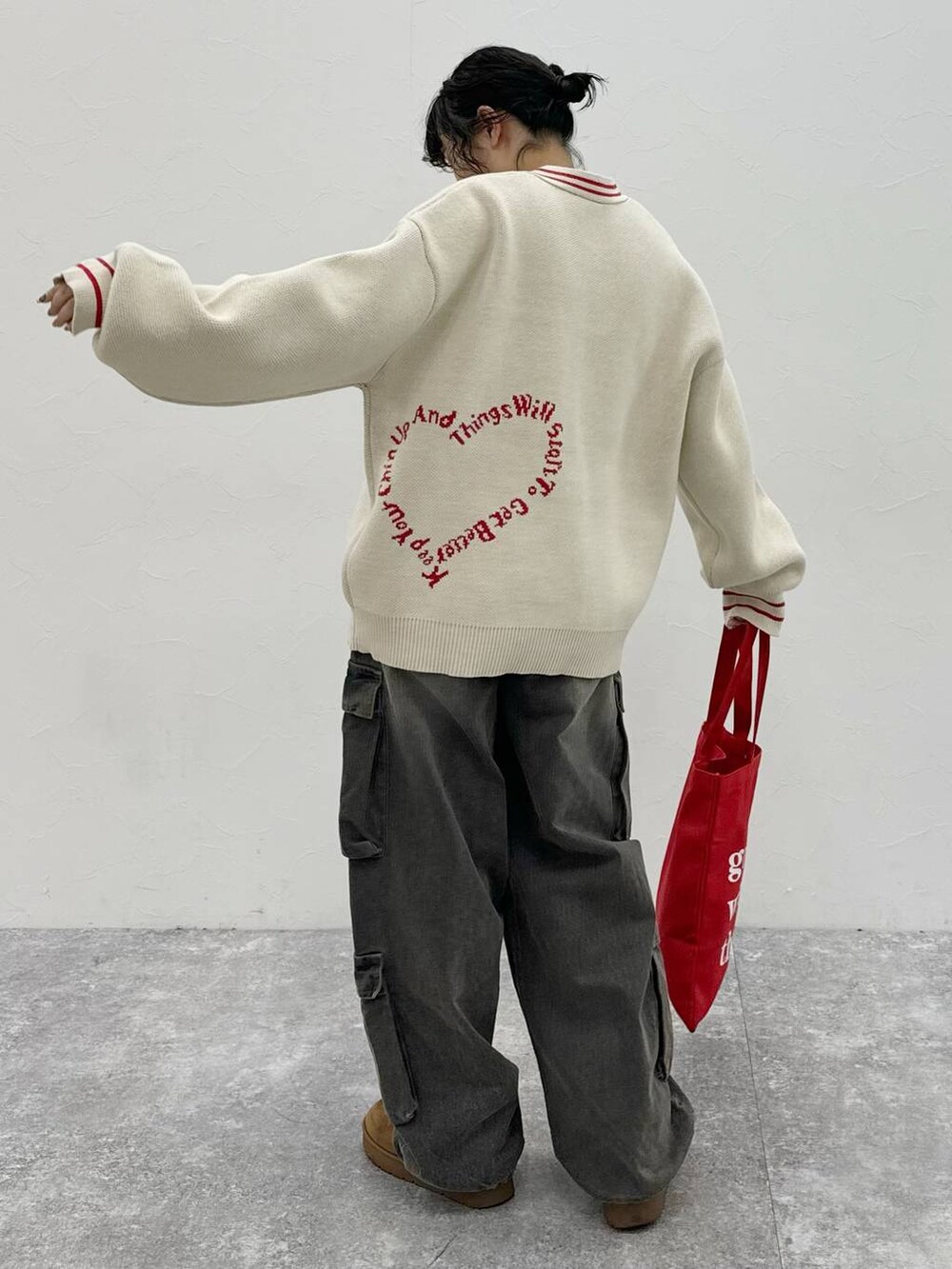 ブラック系のデニムパンツ、ベージュ系のカーディガン/ボレロを着用したレディースの秋コーディネートの2枚目の写真