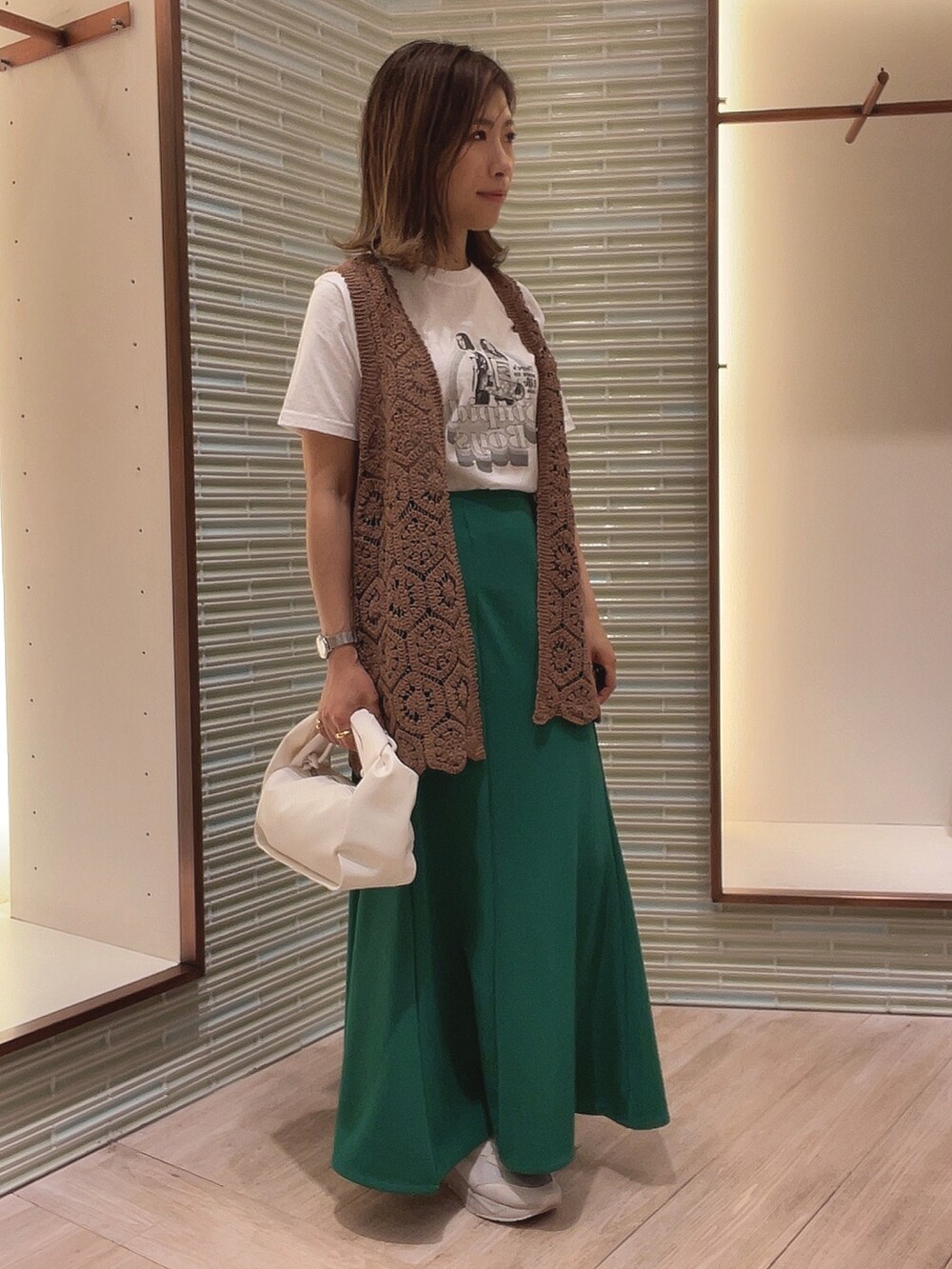 ホワイト系のTシャツ/カットソー、グリーン系のスカート、ブラウン系のベストを着用したレディースの春コーディネートの3枚目の写真