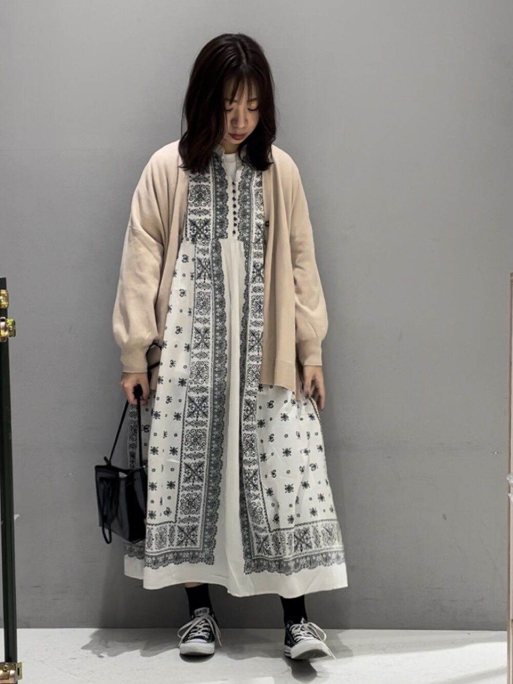 ベージュ系のワンピース、ベージュ系のカーディガン/ボレロ、ブラック系のトートバッグを着用したレディースの春コーディネートの2枚目の写真