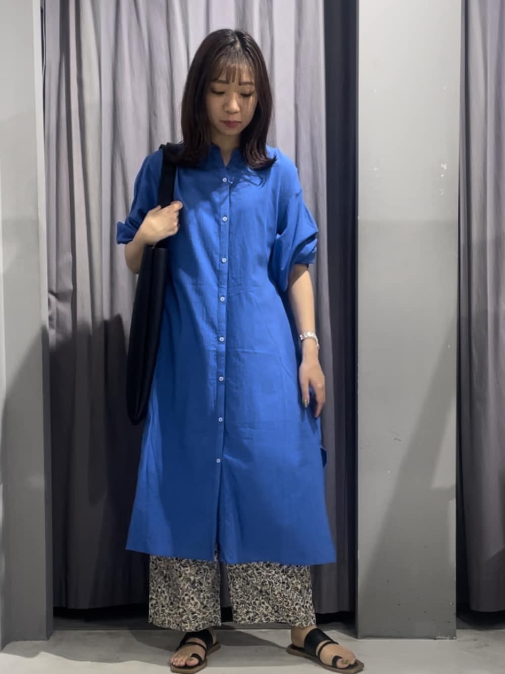 ブルー系のワンピースを着用したレディースの春コーディネートの2枚目の写真