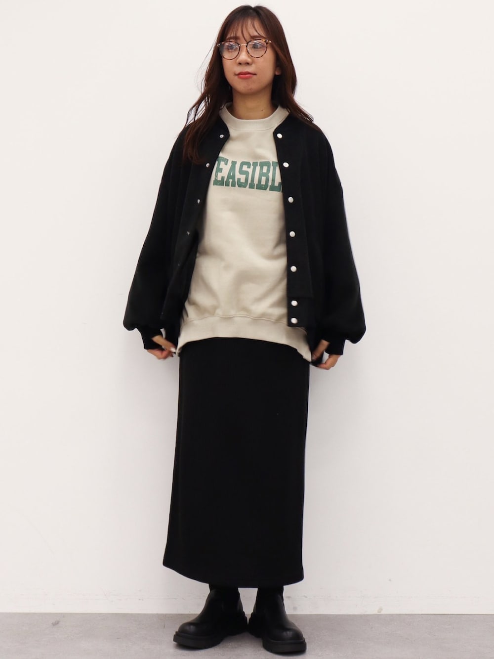 ブラック系のブルゾン、ブラック系のスカート、ベージュ系のスウェットを着用したレディースの冬コーディネートの2枚目の写真