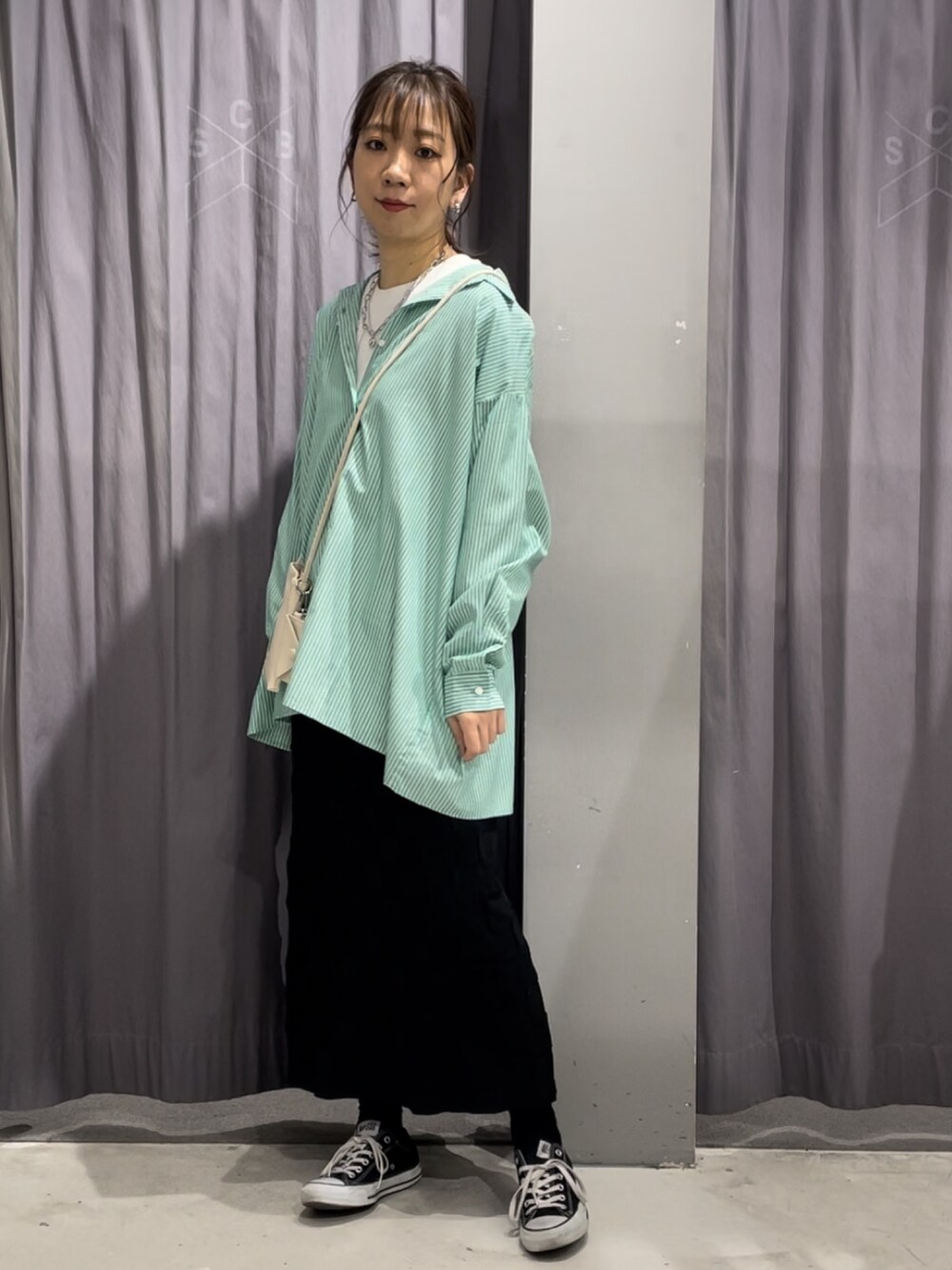 グリーン系のシャツ/ブラウス、ブラック系のスカートを着用したレディースの春コーディネートの2枚目の写真