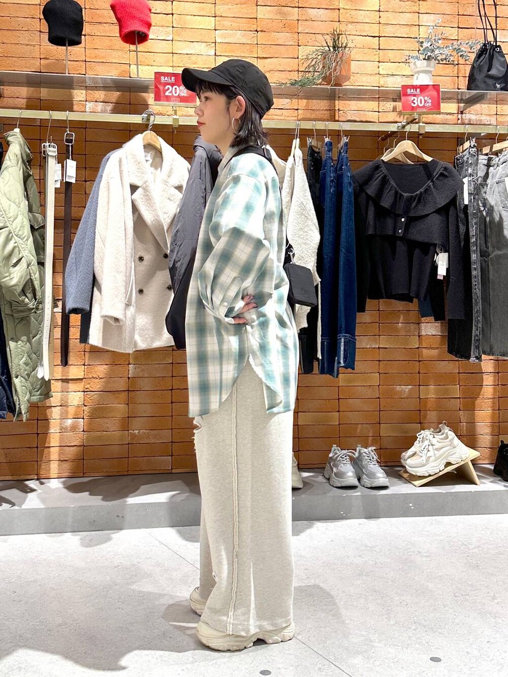 ブラック系のショルダーバッグ、ホワイト系のスニーカー、グリーン系のシャツ/ブラウスを着用したレディースの冬コーディネートの2枚目の写真