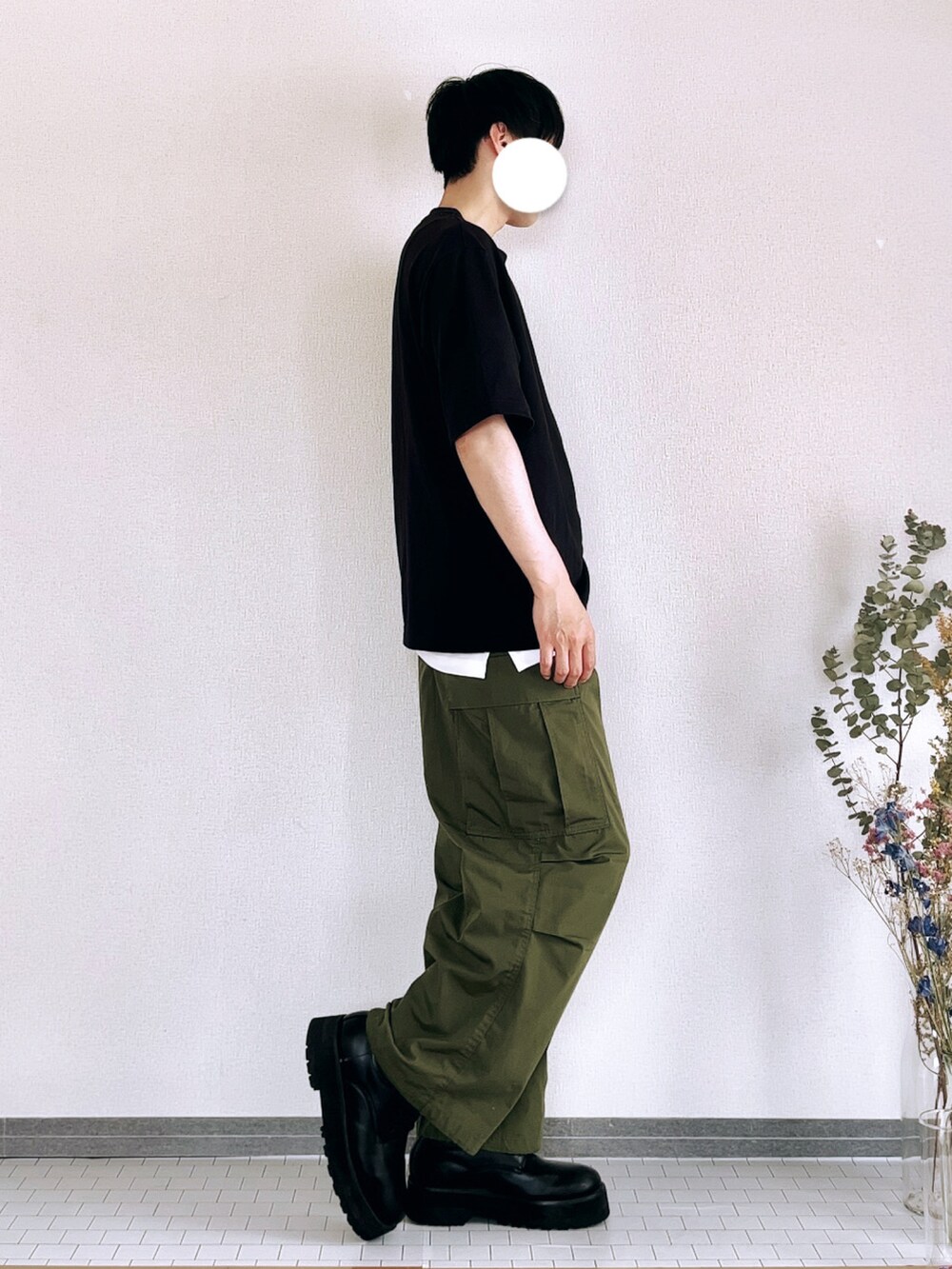 ブラック系のドレスシューズ、グリーン系のカーゴパンツ、ブラック系のTシャツ/カットソーを着用したメンズの春コーディネートの2枚目の写真