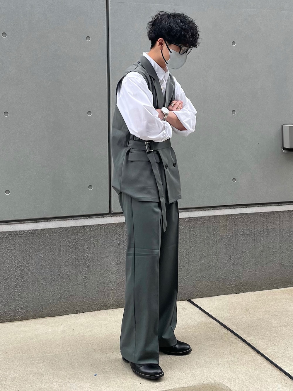 ブルー系のベスト、ブルー系のパンツ、ブラック系のブーツを着用したメンズの春コーディネートの2枚目の写真