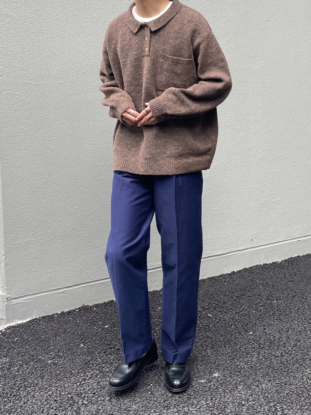 ブラウン系のニット/セーター、ブルー系のパンツ、ブラック系のローファーを着用したメンズの秋コーディネートの2枚目の写真