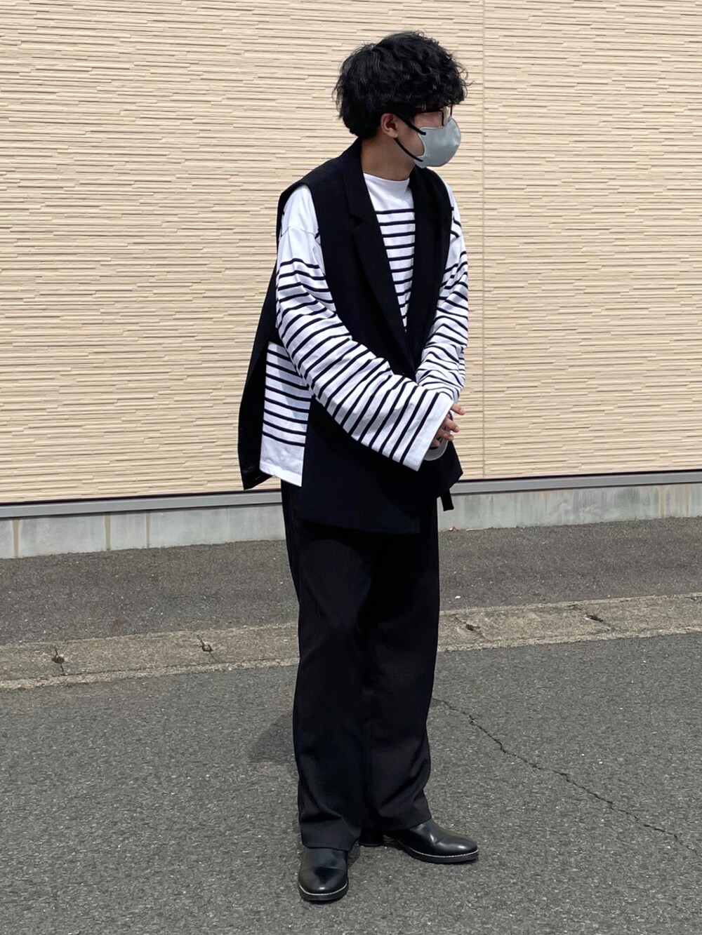 ホワイト系のシャツ/ブラウス、ブラック系のベスト、ホワイト系のパンツを着用したメンズの春コーディネートの2枚目の写真