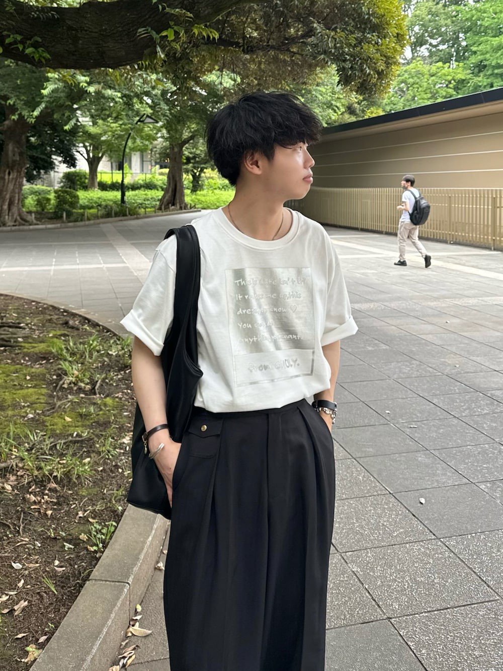 シルバー系のTシャツ/カットソー、ブラック系のスラックスを着用したメンズの夏コーディネートの3枚目の写真