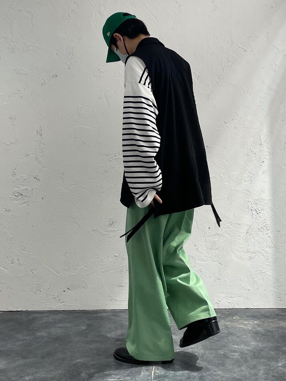 ブラック系のベスト、ホワイト系のシャツ/ブラウス、グリーン系のスラックスを着用したメンズの春コーディネートの3枚目の写真