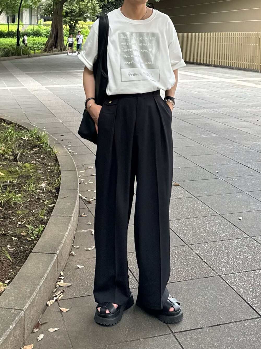 シルバー系のTシャツ/カットソー、ブラック系のスラックスを着用したメンズの夏コーディネートの2枚目の写真