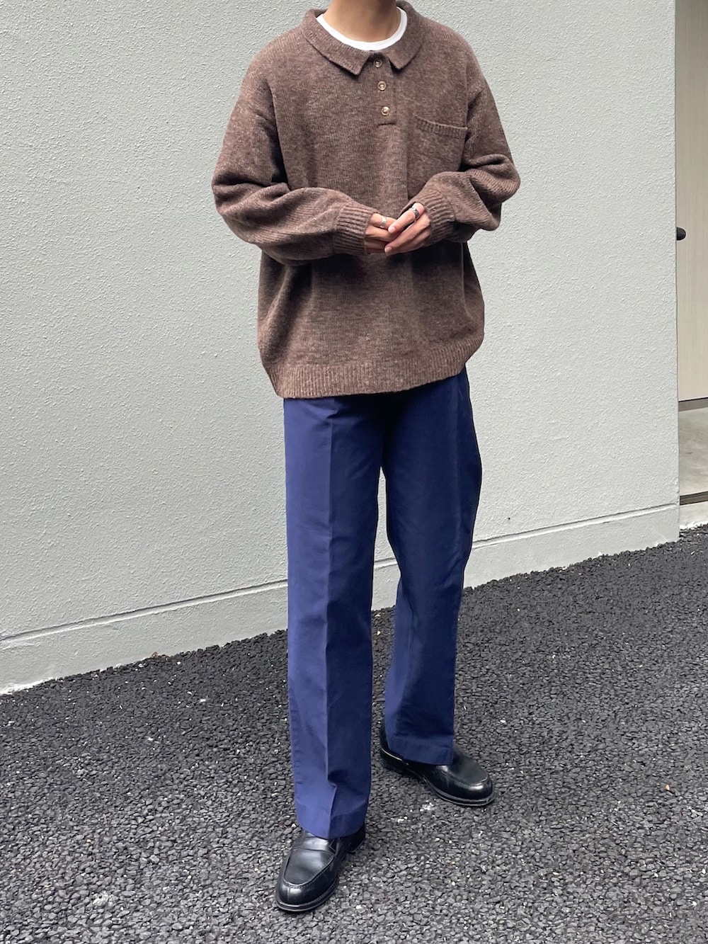 ブラウン系のニット/セーター、ブルー系のパンツ、ブラック系のローファーを着用したメンズの秋コーディネートの3枚目の写真