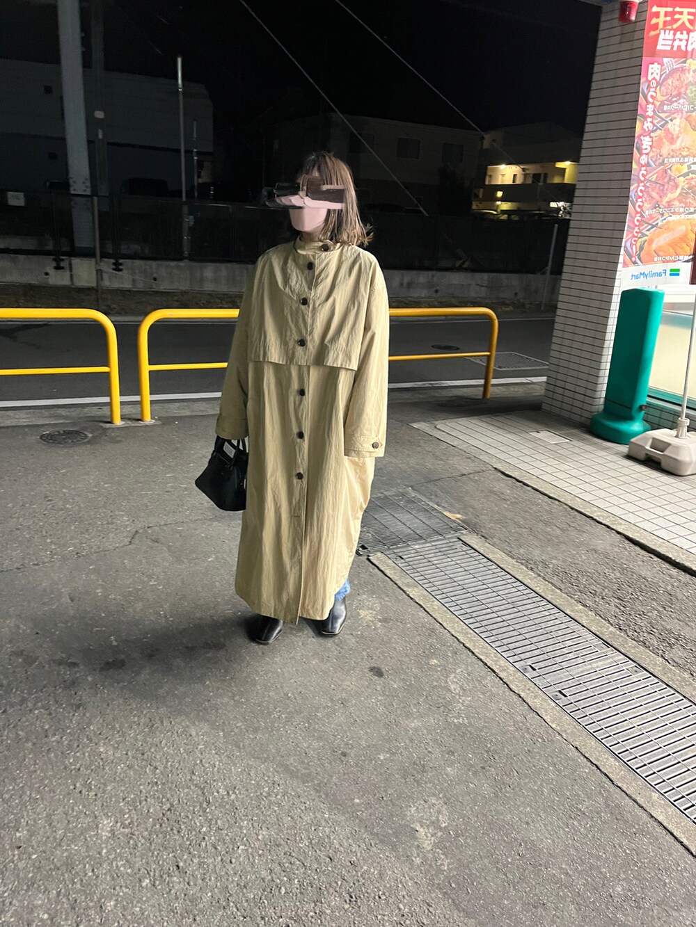 ベージュ系のトレンチコート、ブラック系のハンドバッグ、ブラック系のブーツを着用したレディースの春コーディネートの2枚目の写真