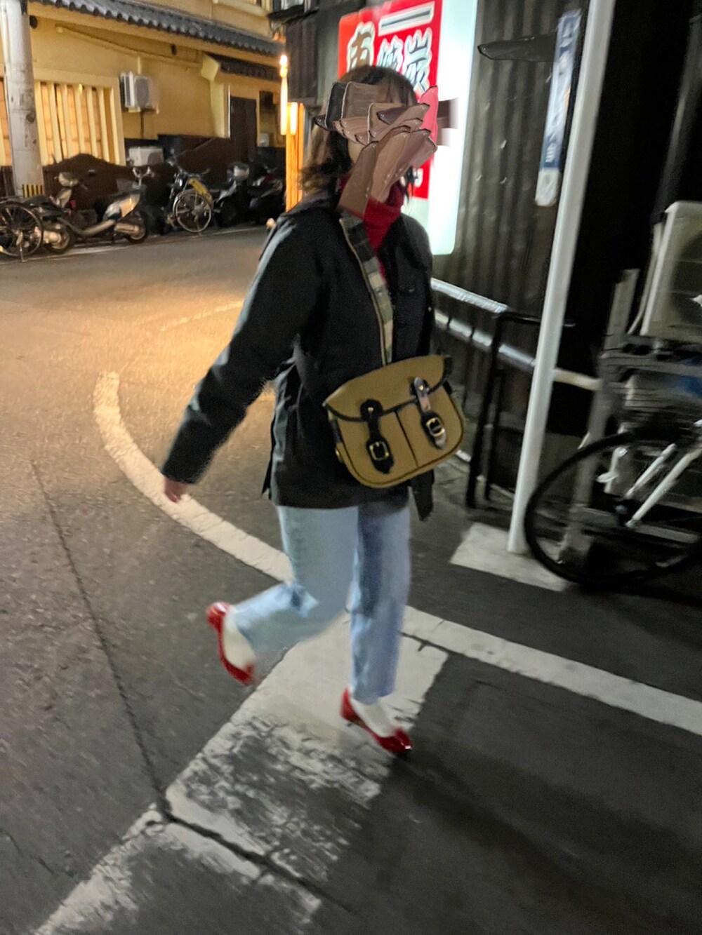 ブラック系のミリタリージャケット、ベージュ系のショルダーバッグ、レッド系のパンプスを着用したレディースの冬コーディネートの3枚目の写真