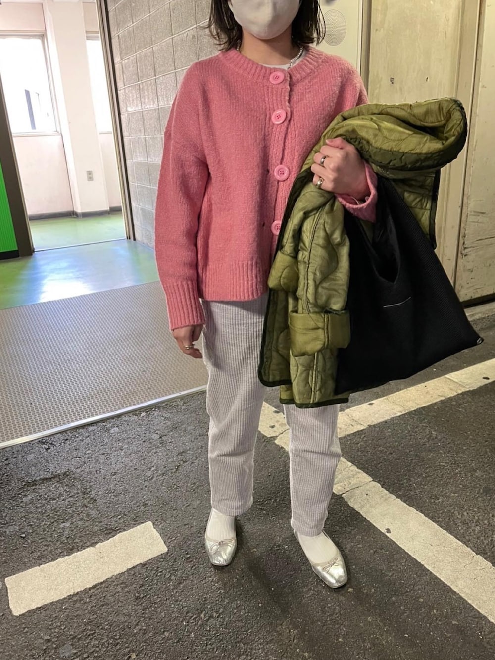 ブラック系のトートバッグ、シルバー系のパンプス、ピンク系のカーディガン/ボレロを着用したレディースの冬コーディネートの2枚目の写真