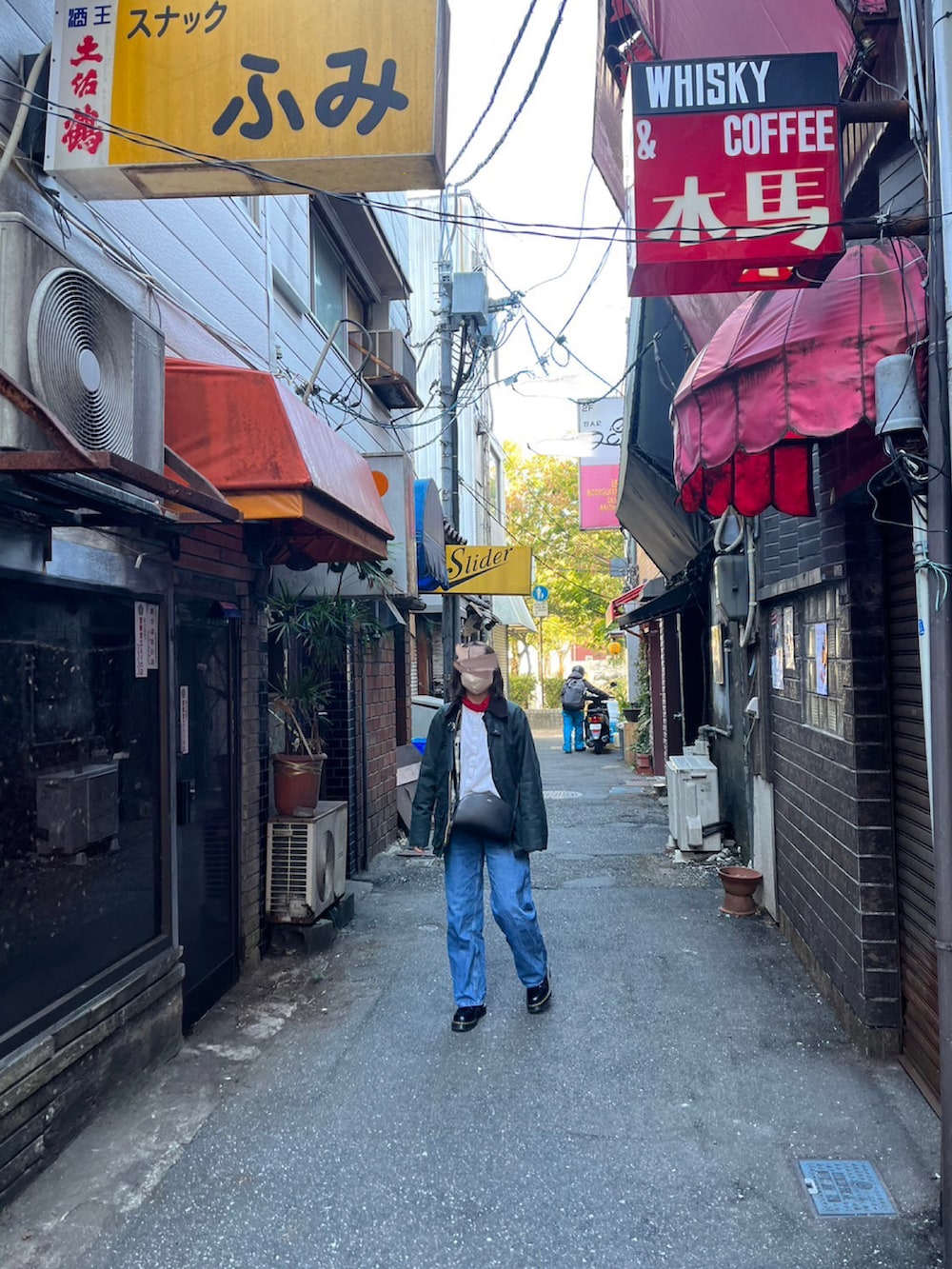 ブラック系のミリタリージャケット、ブラック系のショルダーバッグ、ブラック系のローファーを着用したレディースの冬コーディネートの2枚目の写真