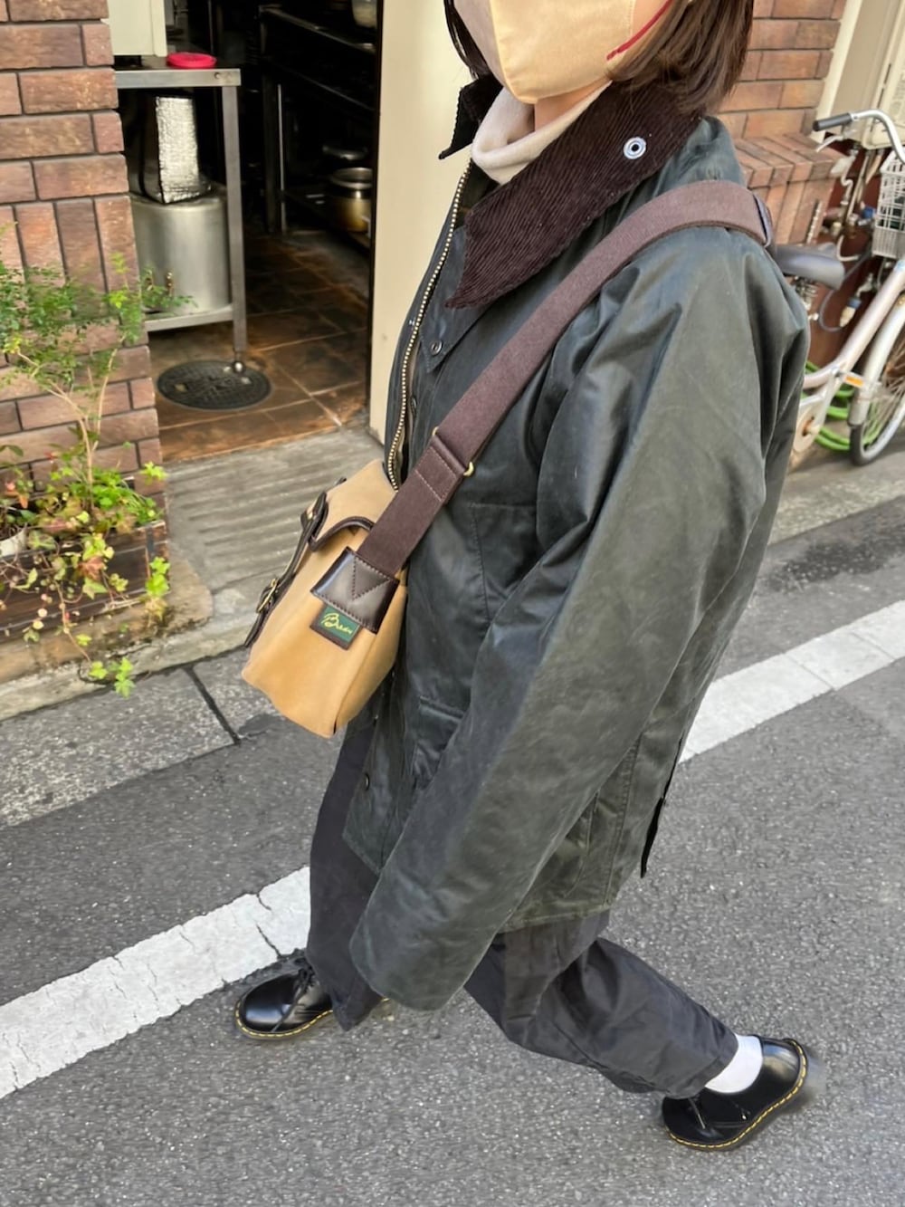 ブラック系のミリタリージャケット、ブラック系のその他パンツ、ブラック系のローファーを着用したレディースの秋コーディネートの3枚目の写真