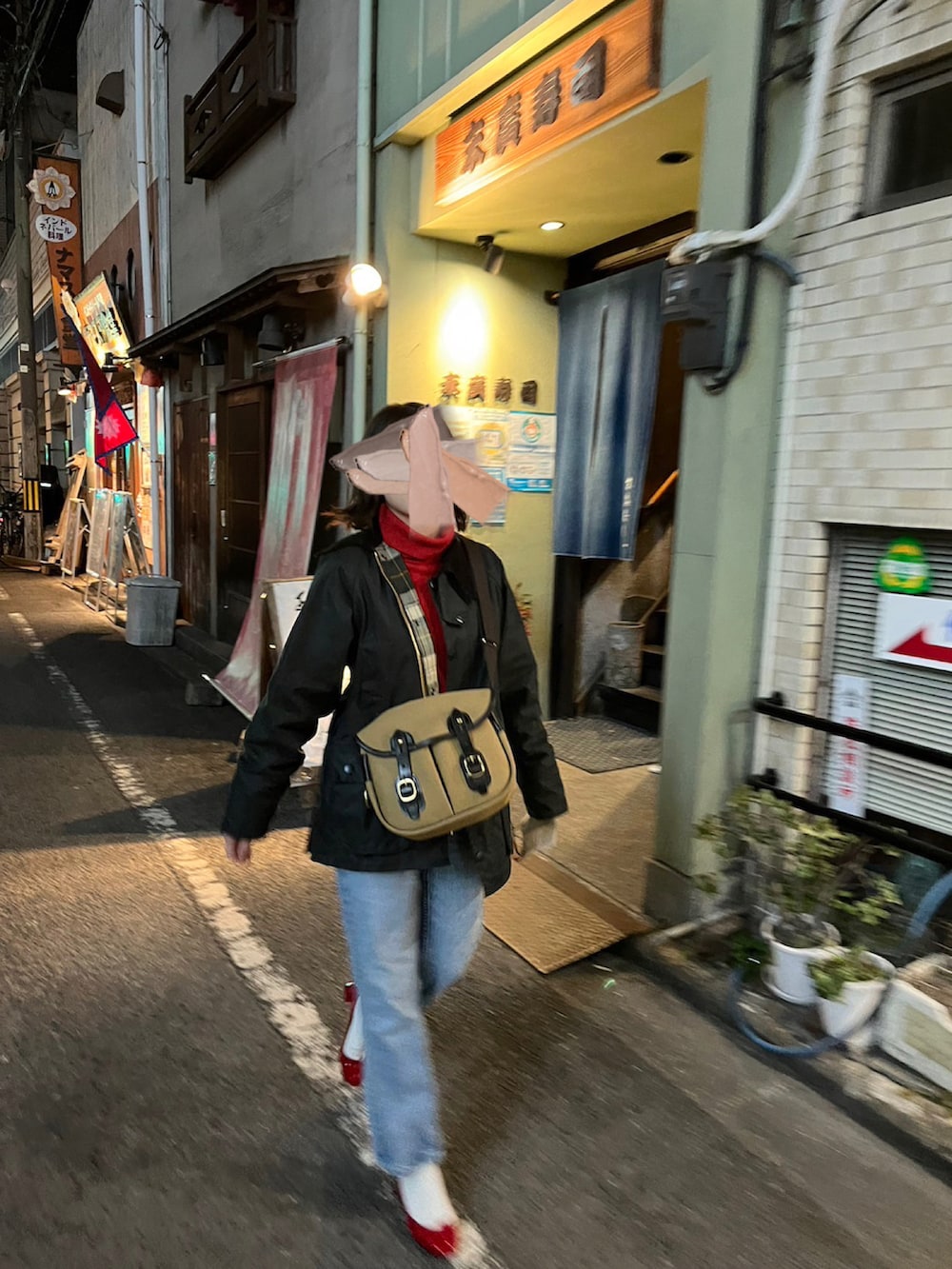 ブラック系のミリタリージャケット、ベージュ系のショルダーバッグ、レッド系のパンプスを着用したレディースの冬コーディネートの2枚目の写真