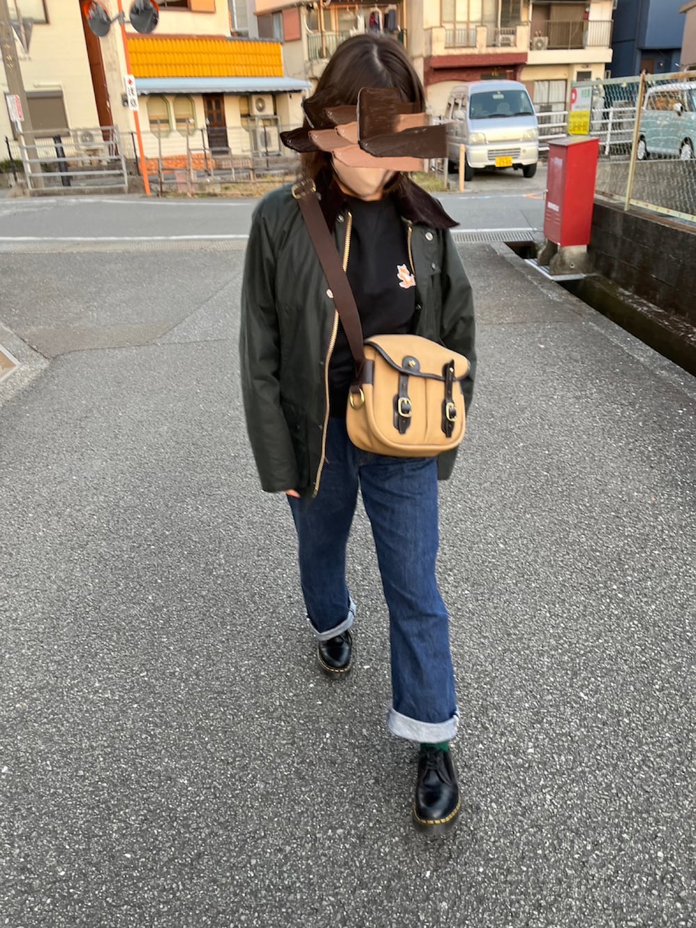 ベージュ系のショルダーバッグ、ブルー系のデニムパンツ、ブラック系のローファーを着用したレディースの冬コーディネートの3枚目の写真