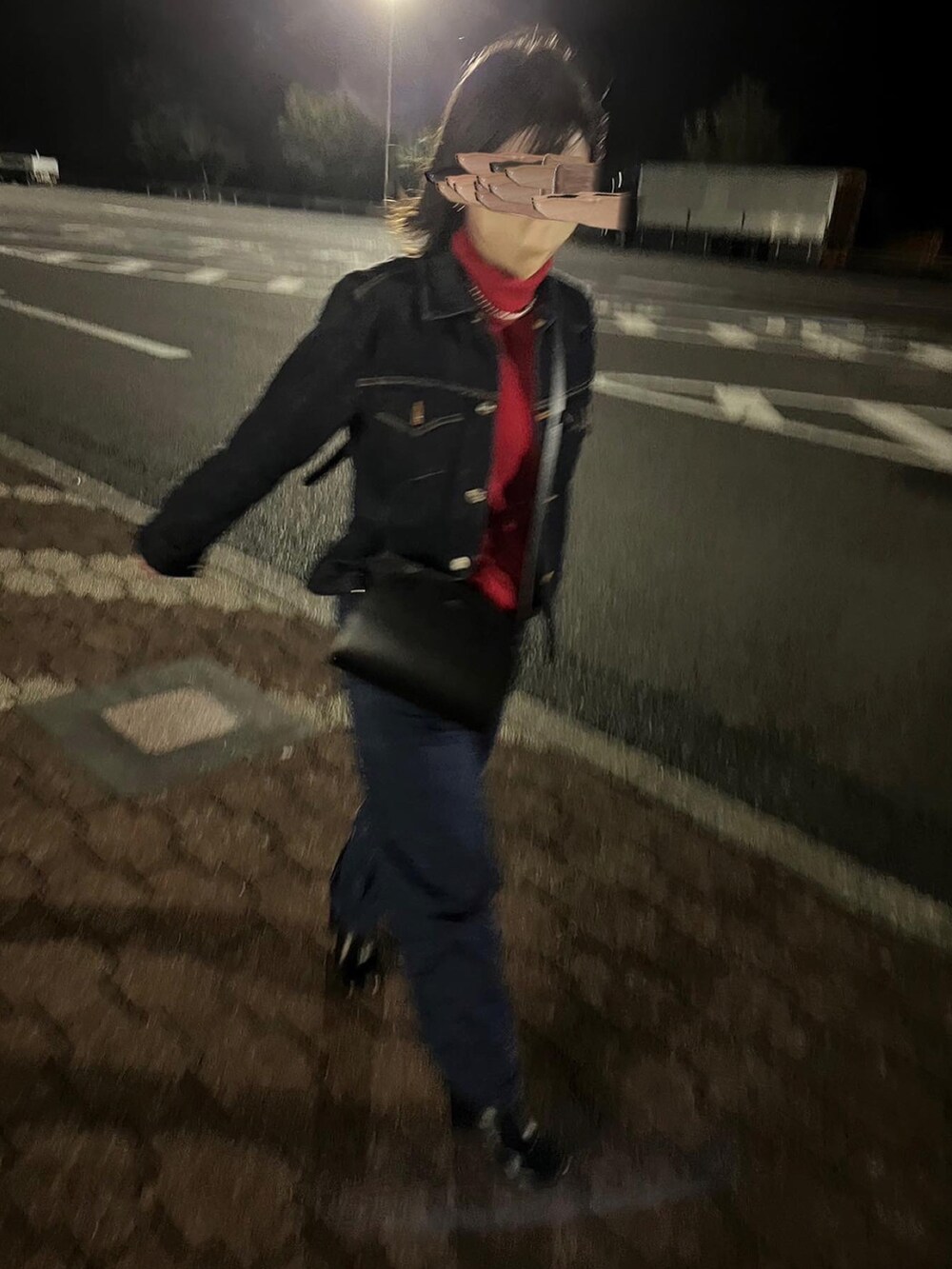 レッド系のニット/セーター、ブラック系のショルダーバッグ、ブルー系のデニムパンツを着用したレディースの冬コーディネートの3枚目の写真