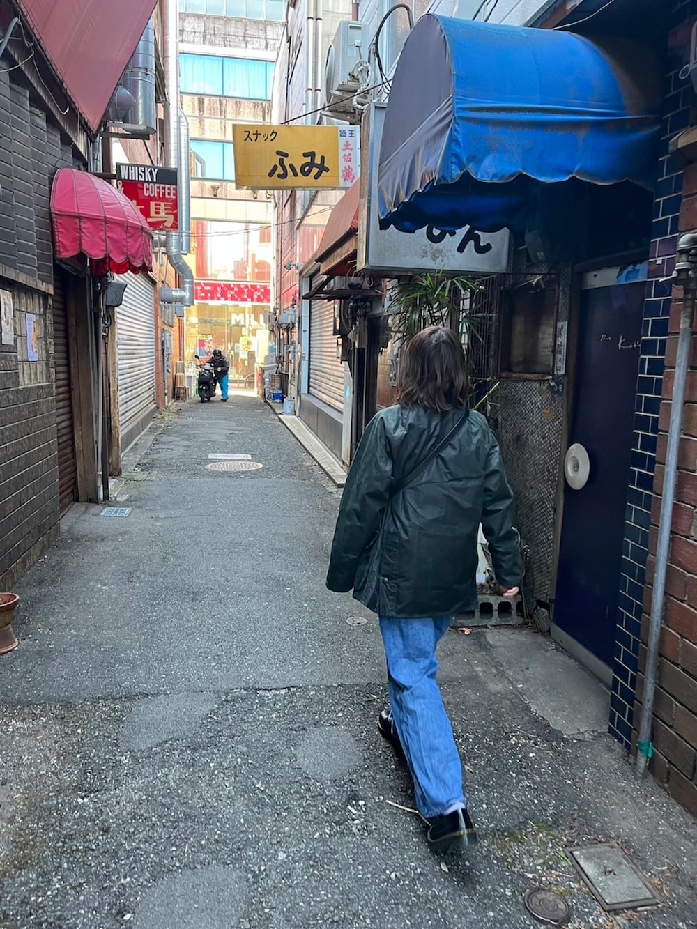 ブラック系のミリタリージャケット、ブラック系のショルダーバッグ、ブラック系のローファーを着用したレディースの冬コーディネートの3枚目の写真