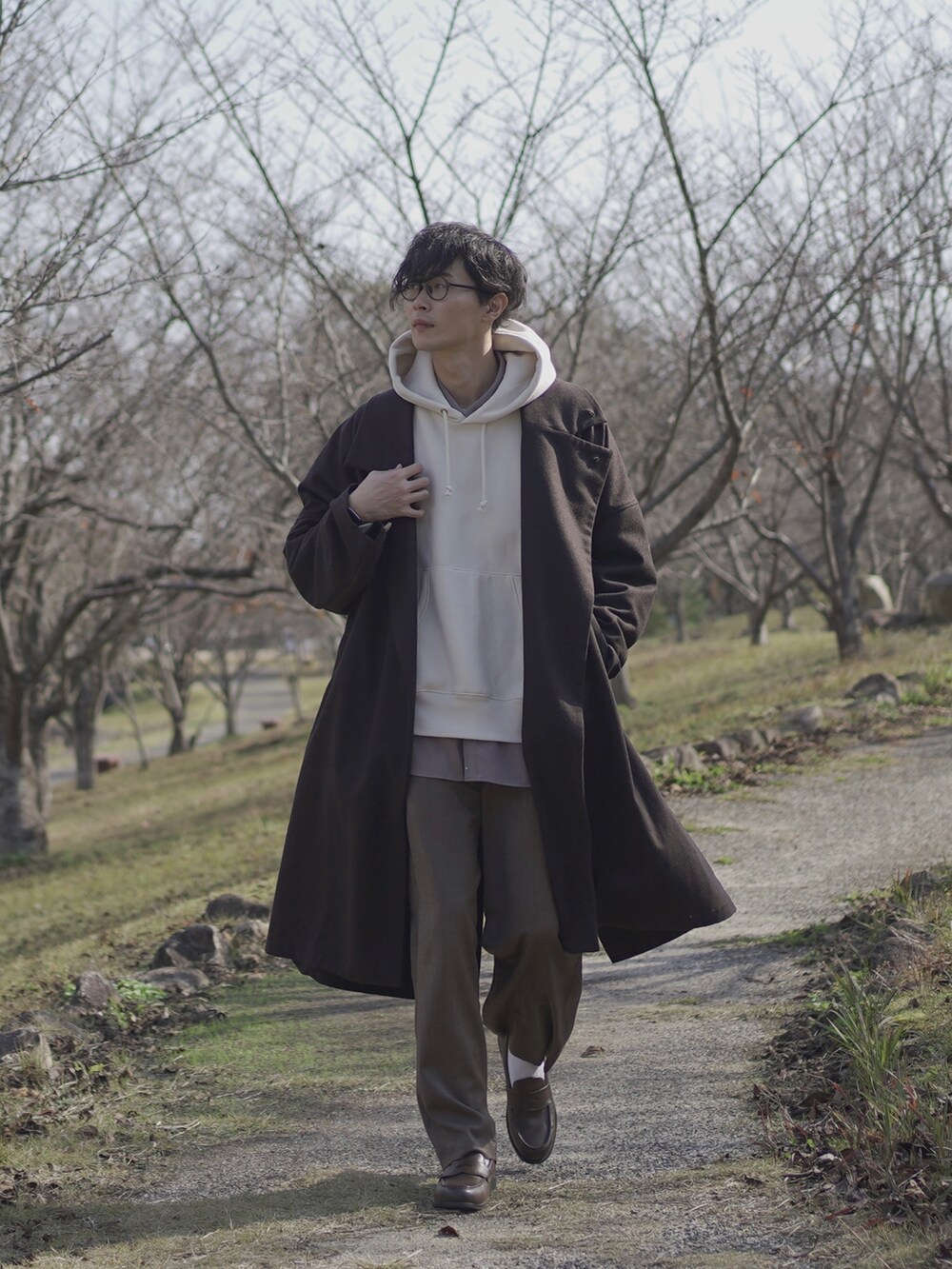 ホワイト系のパーカー、グレー系のトレンチコート、グレー系のシャツ/ブラウスを着用したメンズの秋コーディネートの4枚目の写真