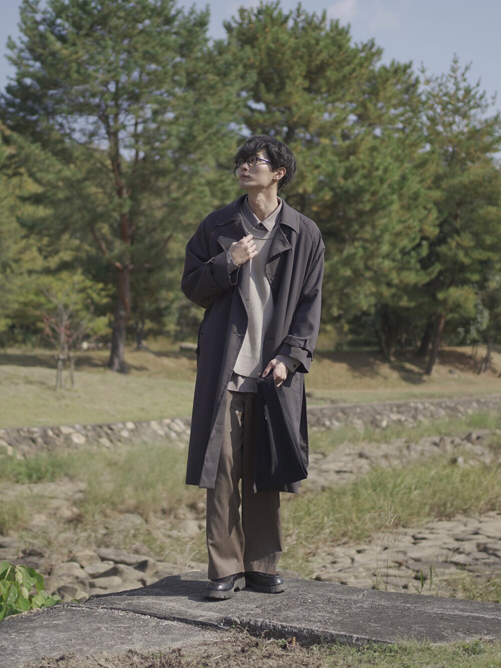 グレー系のトレンチコート、ベージュ系のベスト、グレー系のシャツ/ブラウスを着用したメンズの冬コーディネートの3枚目の写真