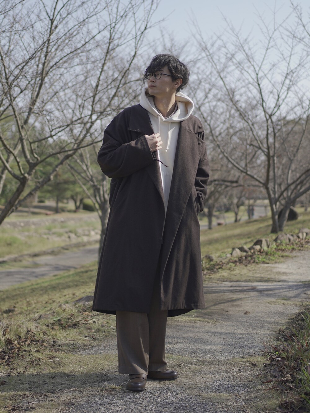 ホワイト系のパーカー、グレー系のトレンチコート、グレー系のシャツ/ブラウスを着用したメンズの秋コーディネートの2枚目の写真