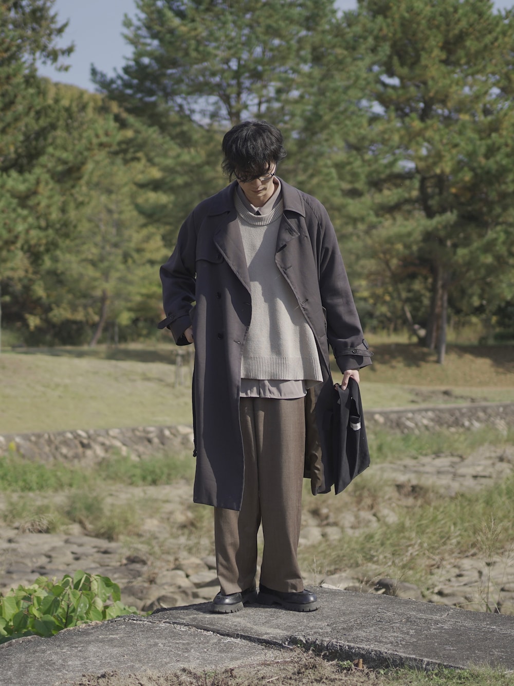 グレー系のトレンチコート、ベージュ系のベスト、グレー系のシャツ/ブラウスを着用したメンズの冬コーディネートの2枚目の写真