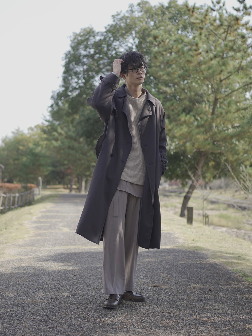 グレー系のトレンチコート、ベージュ系のニット/セーター、グレー系のシャツ/ブラウスを着用したメンズの冬コーディネートの3枚目の写真
